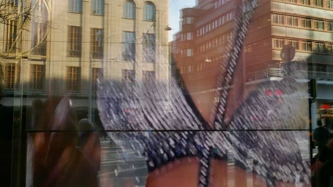 Reflection of people walking in street on window of store showing fashion movie Stock Footage 112081760