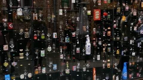 Reflection of people on window full of different kind of beers from around world Stock Footage 98010450