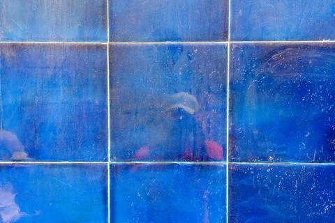 Reflection of a person with a camera in the blue liquid ceramic tile wall. Photos