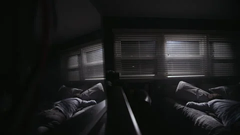 Reflection of person sleeping in a dark room illuminated by moonlight from the Stock Footage 344294292
