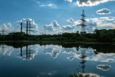 Reflection of a power line and dark cumulus clouds in the water. Stock Photos