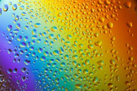 Reflection of the rainbow in the raindrops on the glass. Stock Photos