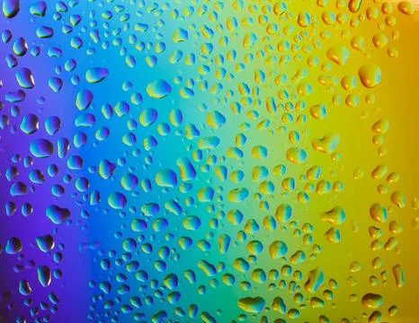 Reflection of the rainbow in the raindrops on the glass. Stock Photos