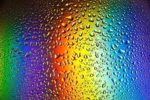 Reflection of the rainbow in the raindrops on the glass. Stock Photos