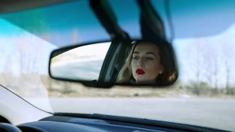 Reflection in rear-view mirror of slim beautiful Caucasian brunette woman Stock Footage 148752244