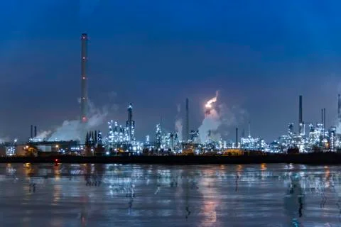 Reflection of refineries and its chimney during the on fire sunset golden hou Stock-Fotos