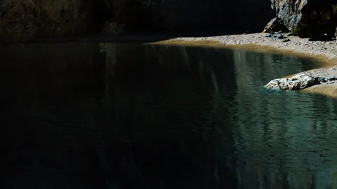 Reflection of rocks and trees on water surface in a hidden location Stock Footage 339503722