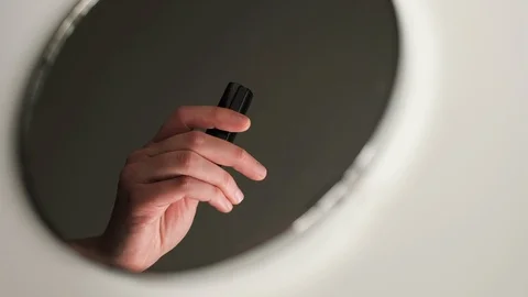 Reflection in the round mirror of female hands opening lipstick. Stock Footage 104606375