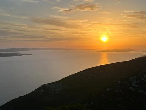 Reflection of the setting sun in sea water, view from the mountain. Sunset .. Stock Photos