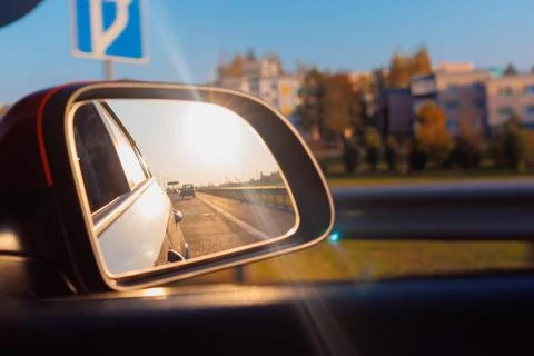 Reflection in the side view mirror. The car is driving in the evening. Stock Photos