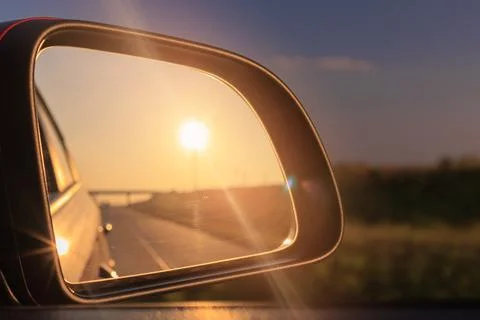 Reflection in the side view mirror. The car is driving in the evening. Stock Photos