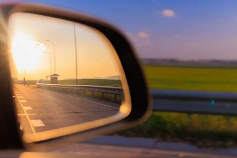 Reflection in the side view mirror. The car is driving in the evening. Stock Photos