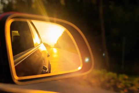 Reflection in the side view mirror. The car is driving in the evening. Stock Photos