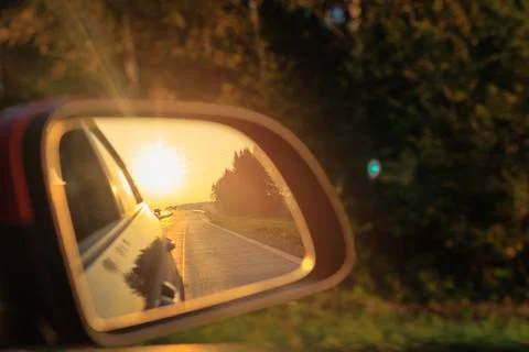 Reflection in the side view mirror. The car is driving in the evening. Stock Photos