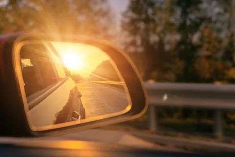 Reflection in the side view mirror. The car is driving in the evening. 스톡 사진