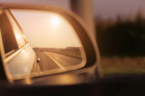 Reflection in the side view mirror. The car is driving in the evening. Stock Photos