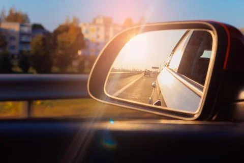 Reflection in the side view mirror. The car is driving in the evening. Stock Photos