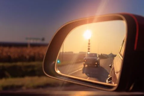 Reflection in the side view mirror. The car is driving in the evening. Foto stock