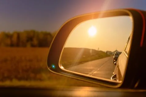 Reflection in the side view mirror. The car is driving in the evening. Stock Photos