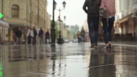 Reflection silhouettes people in pools wet asphalt in rain, Background of rainy Видео 84994696
