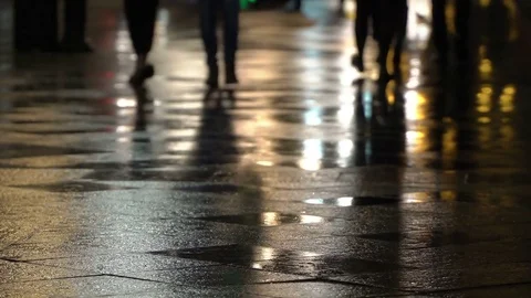 Reflection silhouettes of unrecognizable people on wet pavement in streetlights Stock-Footage 83230930
