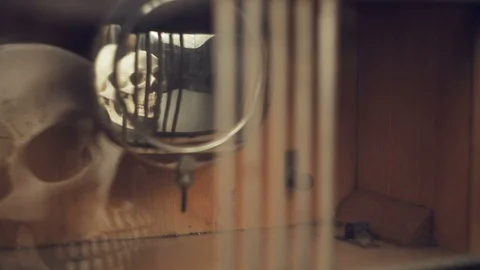 Reflection of the skull and candles in the pendulum of an old clock Vídeo Stock 97865042