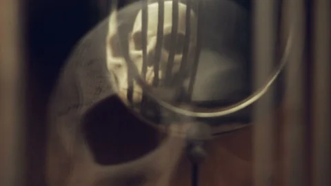 Reflection of the skull and candles in the pendulum of an old clock Stock Footage 97970617