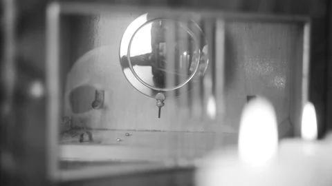 Reflection of the skull and candles in the pendulum of an old clock Stock Footage 100321211