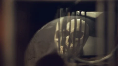 Reflection of the skull and candles in the pendulum of an old clock Stock Footage 100321620