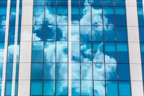 Reflection of the sky and clouds in building windows Stock Photos