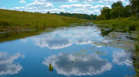 Reflection of the sky and clouds in the river and circles on the water Stock Footage 52668964