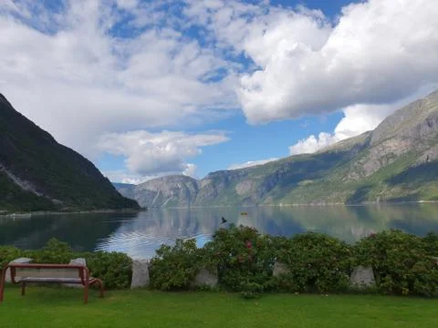 Reflection of the sky and mountains in the blue water of the fjord - Eidfjord Stock Photos