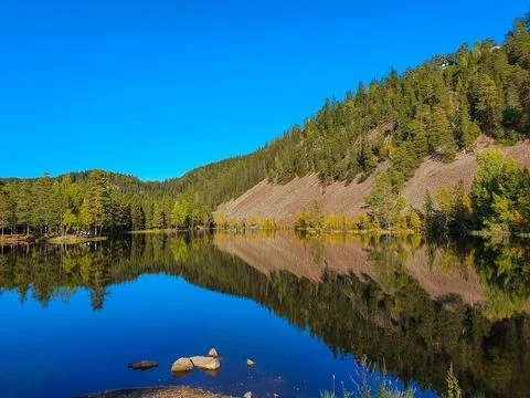 Reflection of sky and mountains in blue water - Strømsdammen Stock Photos