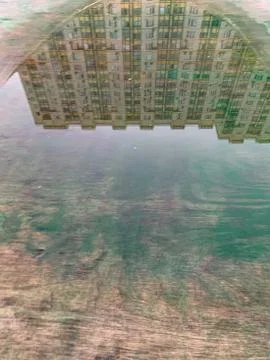 Reflection sky, clouds, building in the puddle on the table tennis Stock Photos
