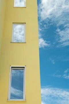 Reflection of a sky with clouds in the mirrored windows of a residential hous Stock Photos