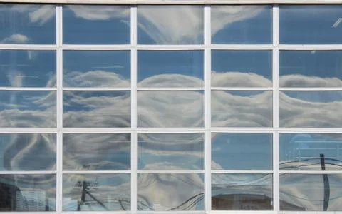 Reflection of the sky with clouds in the windows of a major business center in Stock Photos