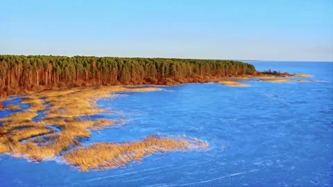 Reflection of the sky in the ice of the lake, super bright colors at golden hour Stock Footage 257769700