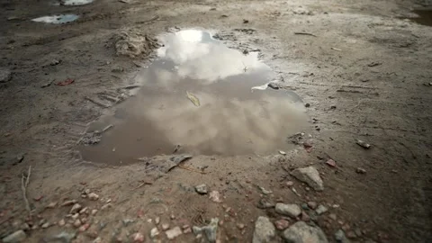 Reflection of the sky in a muddy puddle on a rural road. Stock Footage 254963229