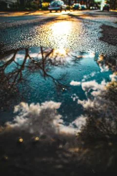 Reflection of sky on puddle at street Foto stock