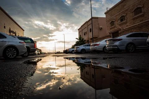 Reflection of sky in a puddle of water after rain fall in a neighborhood Stock Photos