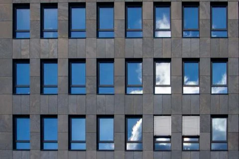 Reflection of the sky in the windows of an office building Stock Photos