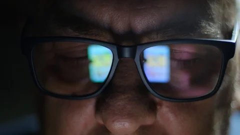 Reflection of a Smartphone Screen in elderly man Glasses at Night Stock-Footage 121752907