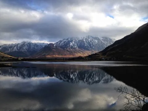 Reflection of a snow capped mountain in a Loch near Dornie, Scotland Stock Photos
