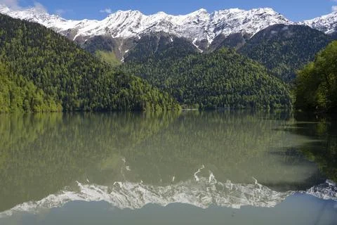 Reflection of snow-capped mountains on the Ritsa lakeon. Abkhazia Photos