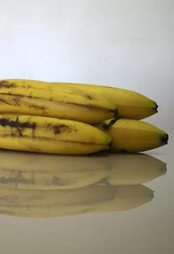The reflection of some bananas on a table Stock Photos