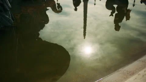 Reflection of statues, sky, and sunlight in calm water, creating a dreamy. Stock Footage 313460784