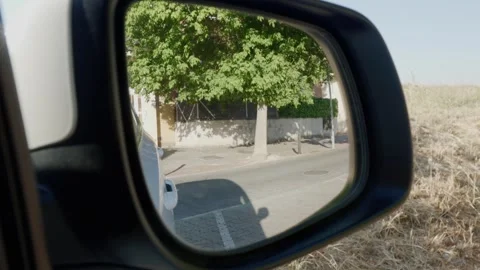 Reflection of a suburban street with trees in a car side view mirror while .. Stock Footage 338226582