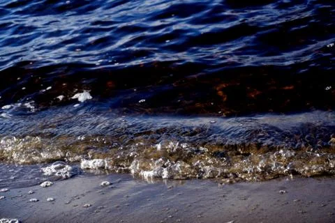 The reflection of the sun, bubbles of water and the sand on the beach of the  Stock Photos