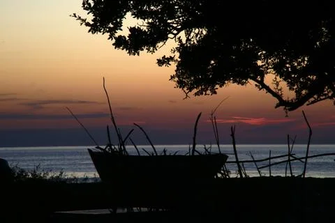A reflection of the sun filtering from the sunset on the boats. Foto stock