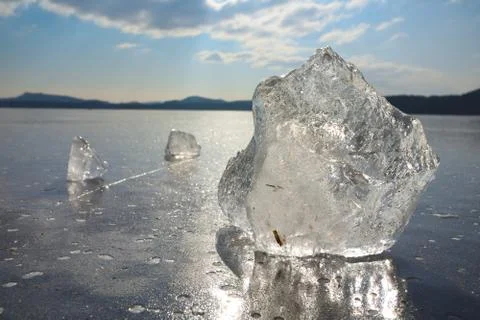 Reflection of sun rays in flat ice on the lake. Air bubbles Stock Photos